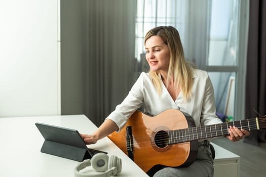 woman blogger live steam playing guitar on social media. High quality photo