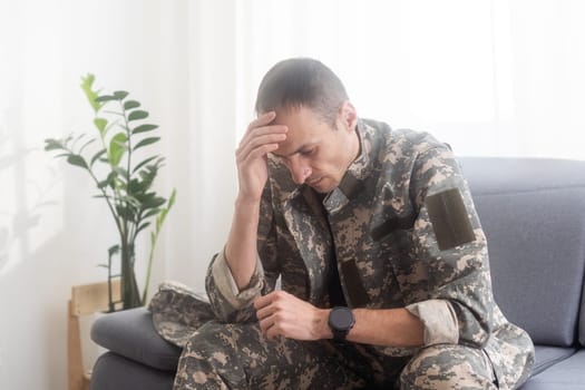 Sad Soldier In Uniform Praying and sitting . High quality photo