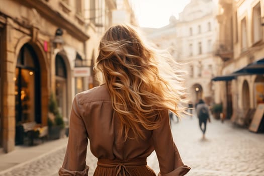 Rear view of a blonde girl in the middle of the street of an old European city.