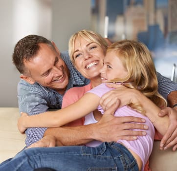 Happy, child and parents on sofa with love, relax and bonding together in home on weekend. Father, mother and daughter with care in family, playing and excited on vacation with hugging in apartment.