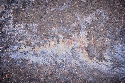 Marble spills on the water from stains of gasoline and oil. Abstract background from motor oil, gas or petrol spilled on asphalt