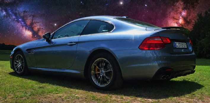 A sleek luxury car parked under a mesmerizing starry night sky. The cosmic backdrop accentuates the vehicle s elegance and modern design.