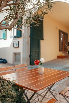 Empty cafe terrace with white table and chair. exterior of the cafe restaurant. interior Street cafe. Cozy street with flowers and French-style cafe table. Decor facade of coffeehouse with bike. Table on a summer terrace with cake and teapot. Garden table and chairs