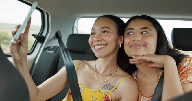 Woman, friends and selfie on road trip with smile, tongue and funny face with adventure in car. Girl, photography and kiss with care, journey or holiday with memory, profile picture or transportation.