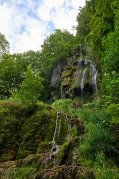 Majestic Cascade: Uracher Wasserfall Amidst Verdant Forest Landscape.