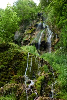 Waterfall Bad Urach at Southern Germany Longexposure. Cascade panorama in Bad Urach Germany is a popular natural attraction and waterfall sight called Uracher Wasserfall . Natural reserve in autumn season with colorful foliage and longtime exposure. Panoramic view of Bruehlbach creek or brook with cascade in Bad Urach, Germany near waterfall sight Uracher Wasserfall . Natural reserve on a summer morning after heavy rain in lush forest.