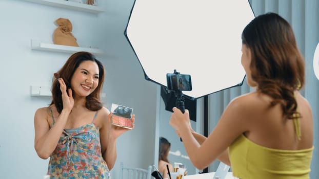 Two influencer partner shoot live streaming vlog video review makeup social media or blog. Happy young girl with vivancy cosmetics studio lighting for marketing recording session broadcasting online.