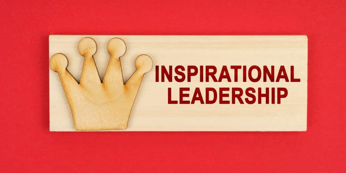 Leader concept. On a red surface there is a wooden block with the inscription - Inspirational leadership