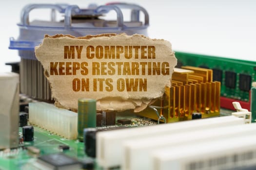 On the computer motherboard there is a cardboard with the inscription - My computer keeps restarting on its own. Computer repair concept.