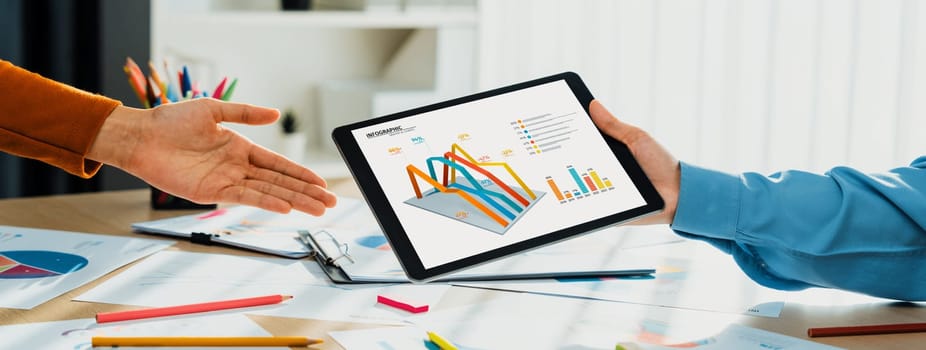 Startup company employee working together using tablet analyzing BI dashboard paper on financial data report and planning strategic marketing for business success in panorama banner. Synergic