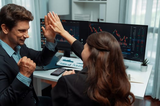 Successful in two business traders making hands high five with fist up to earn highest profit stock market in value currency online website on pc screens in real time data at modern office. Postulate.