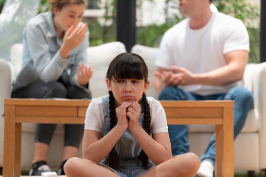 Stressed and unhappy young girl crying and trapped in middle of tension by her parent argument in living room. Unhealthy domestic lifestyle and traumatic childhood develop to depression. Synchronos