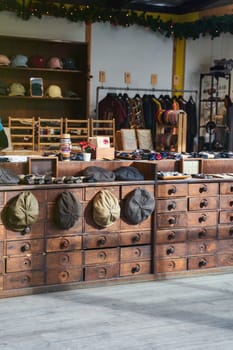 A store showcasing a variety of hats on display atop wooden counters made of hardwood and stained with wood stain. The ambiance is a mix of metal and wood, perfect for any event