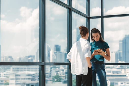 Portrait of young beautiful professional architect engineer team discuss about house design. Skilled businesswoman brainstorming and sharing marketing ideas surrounded by skyscraper. Tracery.