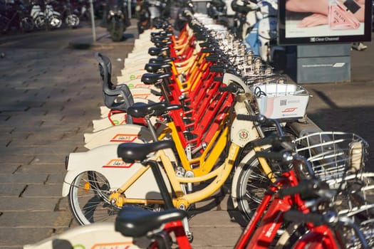 A row of bicycles are parked with their wheels neatly lined up, showcasing the different styles of bicycle tires and handlebars