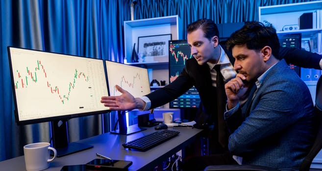 Stock exchange traders looking on high profit chart investment in panorama view, analyzing on monitor at night. Concept of discussing financial technology growth in neon light at workplace. Sellable.