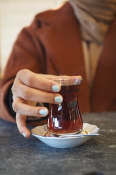 women holding aTraditional turkish tea.