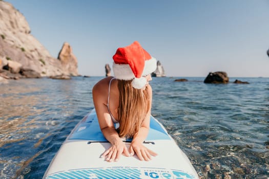 Close up shot of happy young caucasian woman looking at camera and smiling. Cute woman portrait in bikini posing on a volcanic rock high above the sea