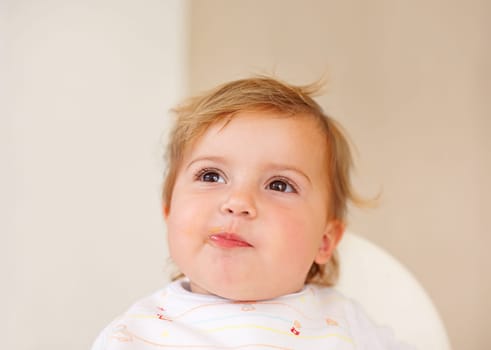 Happy, baby and eating as thinking of food, tasty and messy for healthy, childhood and development. Smile, cute child and hungry for meal, delicous and nutrition for wellbeing, health and growth.