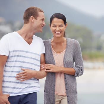 Couple, hug and walking together on the beach for travel, laughter and happiness outdoor. Romantic adventure, love and comedy for bonding, support and trust with commitment on holiday in Mexico.