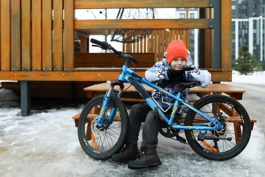 A male child rides a sports bike in the cold season.