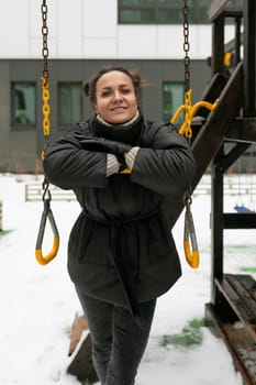 Weekend concept, young woman with bun hairstyle walking on the playground in winter.