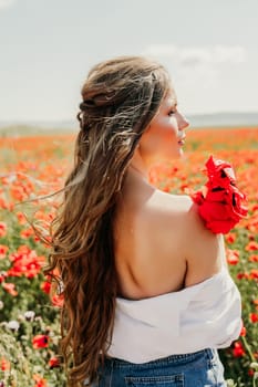 Woman poppies field. Side view of a happy woman with long hair in a poppy field and enjoying the beauty of nature in a warm summer day