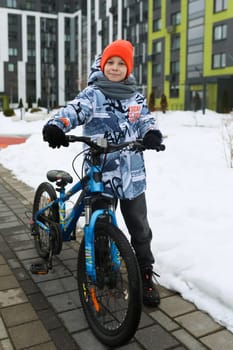 Cute boy riding a bike in the city.