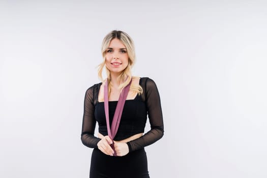 Young woman workout with resistance band on a white background. Strength and motivation.