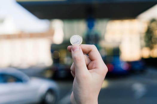 Euro coin and refueling of a car at gas station in city, expensive fuel oil