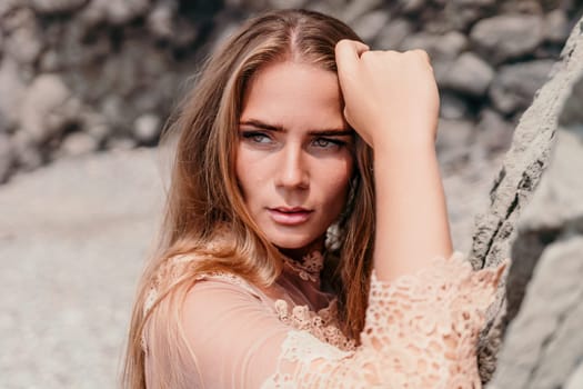 Woman travel sea. Young Happy woman in a long red dress posing on a beach near the sea on background of volcanic rocks, like in Iceland, sharing travel adventure journey