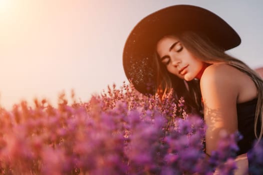 Close up portrait of young beautiful woman in a white dress and a hat is walking in the lavender field and smelling lavender bouquet.