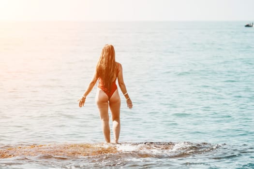 Woman sea yoga. Back view of free calm happy satisfied woman with long hair standing on top rock with yoga position against of sky by the sea. Healthy lifestyle outdoors in nature, fitness concept.