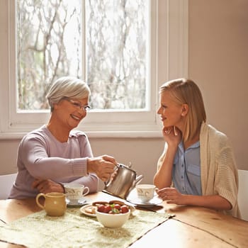 Family, mother and daughter with tea for drink, relaxing and communication with conversation. Happy people, women and smile with coffee at home in table or kitchen, talking and laughing in house.