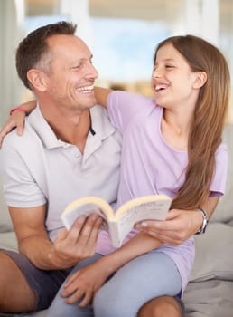 Father, girl and book on sofa for laughing with hug, care or connection in family home for reading. Dad, child and happy together on couch with teaching, education or embrace for funny story in house.