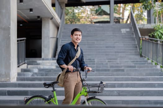 Eco friendly, Happy lifestyle asian young businessman ride bicycle go to office work at city street with bicycle in morning.