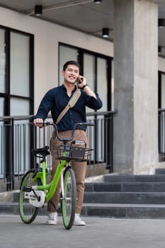 Eco friendly, Happy lifestyle asian young businessman ride bicycle go to office work at city street with bicycle in morning.