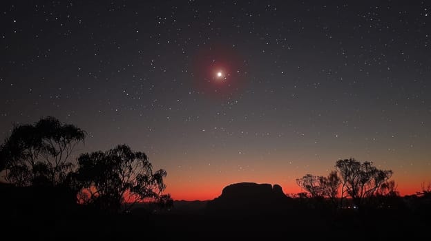 A bright red star is seen in the sky above a mountain