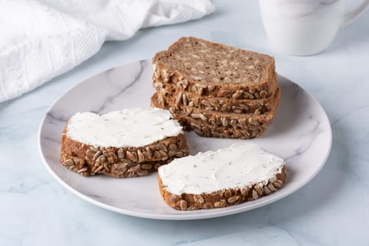 Slices of rye bread with cottage cheese.
