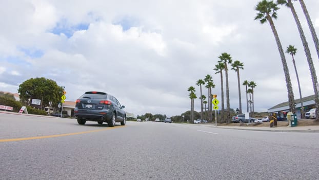 Santa Maria, California, USA-December 6, 2022-Vehicle navigates the streets of Morro Bay, California, during a cloudy winter day. The atmosphere is moody and serene as the overcast sky casts a soft light on the charming buildings and quiet streets of this coastal town.