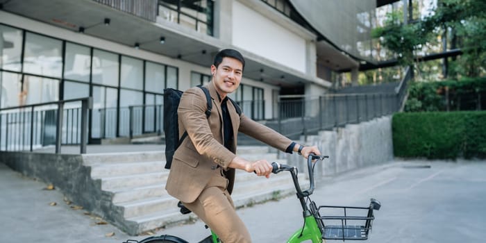 Young businessman in suit in city bike to work eco friendly alternative vehicle green energy.