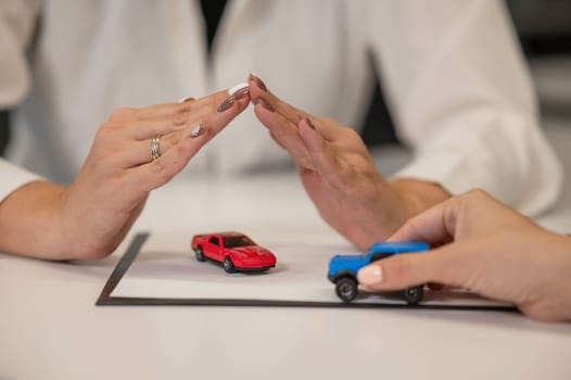 Close-up of woman's hands and car insurance agent