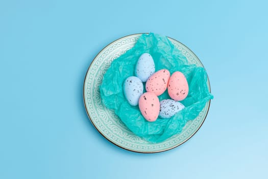 Nest with Easter eggs on the dish. Top view with copy space.