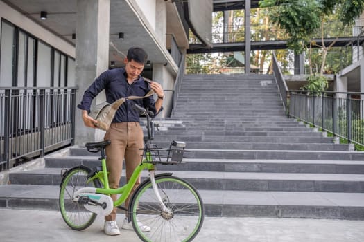 Young Asian businessman Go to work by cycling to reduce air pollution and stay healthy..