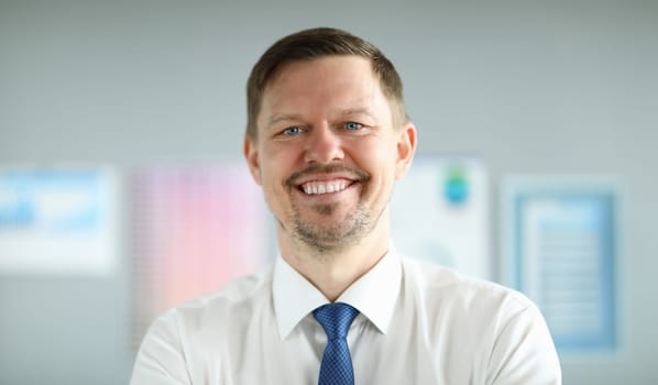 Close-up of smiling middle-aged businessman wearing presentable suit. Copy space in left side. Macro shot of happy employee with shining smile. Business company concept