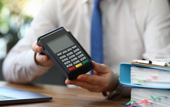 Close-up view of male showing and recommend modern device for payments using plastic credits. Contactless pay via mobile phone or cards. Technology concept