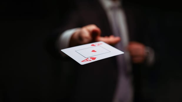 Close-up of male throwing trump out of sleeve. Professional player in presentable suit. Addiction gamers and risk. Strategy and business card game concept