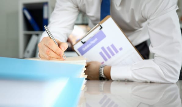 Close-up of male hand signing important documents. Businessman preparing statement for board of directors on conversation. Business meeting and company concept