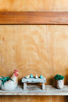 Still life image of Wooden bench and small birds with plant pot on wooden background.