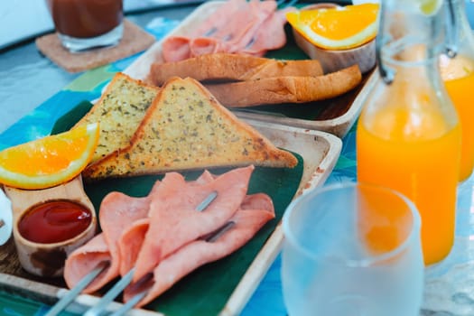 Breakfast with bread, ham, cheese, orange juice and juice